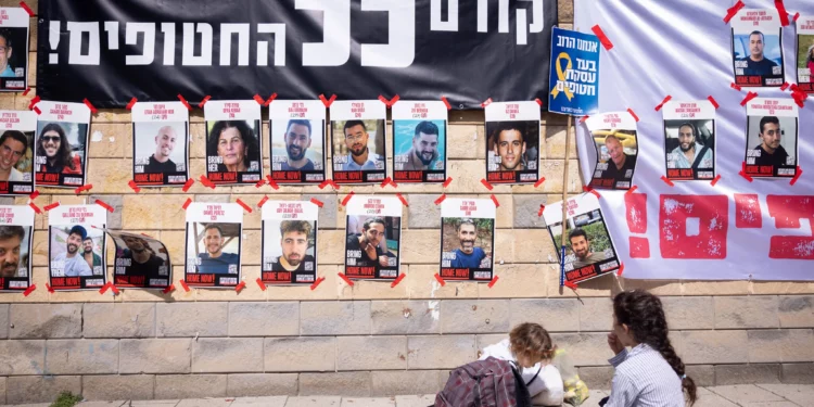 Afuera del Ministerio de Defensa en Tel Aviv se ven carteles de israelíes tomados como rehenes en Gaza, bajo una pancarta que dice: “¡Primero, los rehenes!”, el 9 de marzo de 2025. (Miriam Alster/FLASH90)