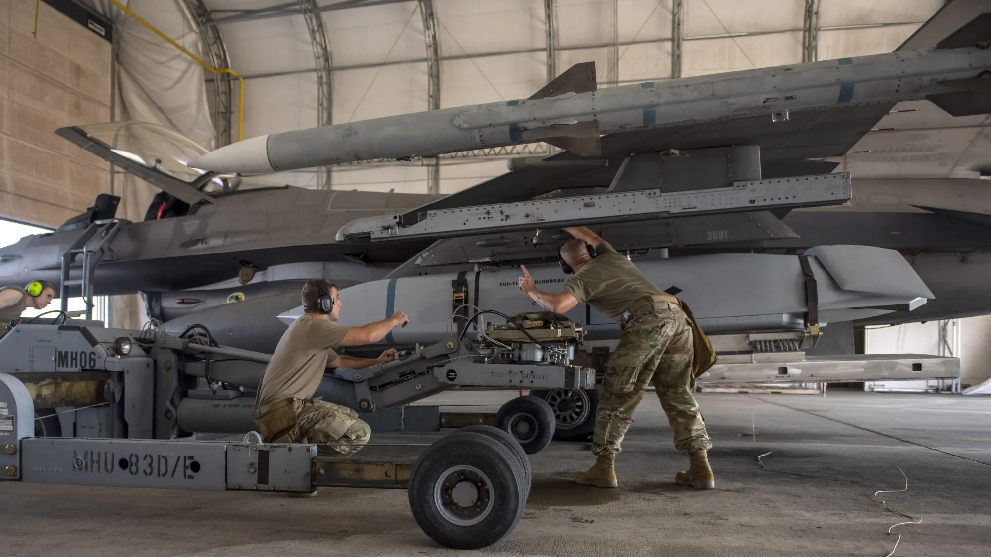 El Sargento Técnico de la Fuerza Aérea de los EE. UU. Peter Giesige y el Aviador de Primera Clase Brian Bowser, ambos especialistas en armas asignados a la 180ª Ala de Combate de la Guardia Nacional de Ohio, y la Sargento Katelyn Barrow, especialista en municiones también asignada al 180FW, cargan con éxito un JASSM AGM-158 en un F-16 Fighting Falcon durante una prueba de estrés de Empleo de Combate Ágil en Swanton, Ohio, 12 de septiembre de 2024. (Foto de la Fuerza Aérea de los EE. UU. por el aviador de 1ª clase Camren Ray)