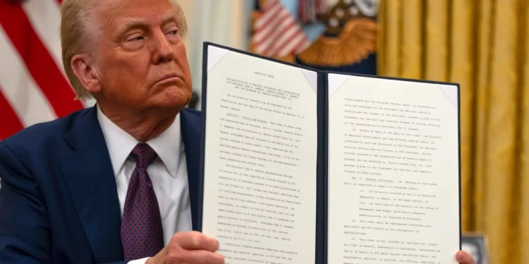 El presidente de Estados Unidos, Donald Trump, sostiene una orden ejecutiva firmada con el objetivo de desclasificar los registros federales restantes relacionados con los asesinatos del presidente John F. Kennedy, el senador Robert F. Kennedy y Martin Luther King Jr., en el Despacho Oval de la Casa Blanca, en Washington, el 23 de enero de 2025. (Ben Curtis/AP)
