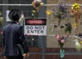 A member of the Jewish community reads messages attached to a fence where flowers have been left at the Adass Israel Synagogue in the Melbourne suburb of Ripponlea on December 9, 2024. (Martin Keep / AFP)