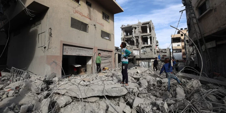 Niños palestinos caminan entre los escombros de un edificio destruido en un ataque israelí en el campo de refugiados de Bureij, en el centro de la Franja de Gaza, el 27 de abril de 2025. (Eyad BABA / AFP)