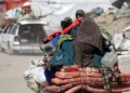 Una mujer palestina sentada sobre las pertenencias de su familia mientras la gente huye de la ciudad de Gaza el 16 de mayo de 2025. (Bashar TALEB / AFP)