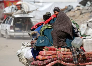 Una mujer palestina sentada sobre las pertenencias de su familia mientras la gente huye de la ciudad de Gaza el 16 de mayo de 2025. (Bashar TALEB / AFP)