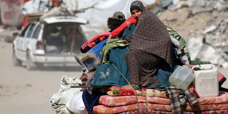 Una mujer palestina sentada sobre las pertenencias de su familia mientras la gente huye de la ciudad de Gaza el 16 de mayo de 2025. (Bashar TALEB / AFP)