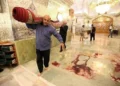 Trabajadores limpian la escena tras un ataque armado en el mausoleo de Shah Cheragh, en la ciudad iraní de Shiraz, en el que murieron 15 personas, el 26 de octubre de 2022. (AGENCIA DE NOTICIAS ISNA/AFP)
