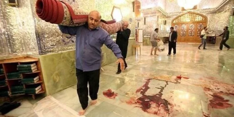 Trabajadores limpian la escena tras un ataque armado en el mausoleo de Shah Cheragh, en la ciudad iraní de Shiraz, en el que murieron 15 personas, el 26 de octubre de 2022. (AGENCIA DE NOTICIAS ISNA/AFP)