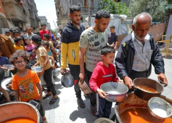 Palestinos reciben comidas de voluntarios en Deir al-Balah, en la Franja de Gaza, el 19 de abril de 2025. (Ali Hassan/Flash90)