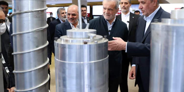 Una fotografía proporcionada por la presidencia iraní muestra al presidente iraní Masoud Pezeshkian (segundo por la derecha) y al jefe de la Organización de Energía Atómica de Irán (OEAI), Mohammad Eslami (derecha), durante el “Día Nacional de la Tecnología Nuclear”, en Teherán, el 9 de abril de 2025 (Presidencia iraní / AFP)