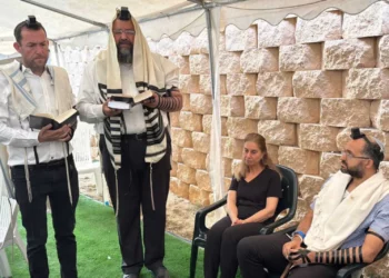 Hananel Gez (derecha) se sienta durante una ceremonia para ponerle nombre a su bebé, quien nació por cesárea de emergencia después de que su madre muriera a tiros en un ataque terrorista, el 20 de mayo de 2025. (Cortesía del asentamiento de Bruchin)