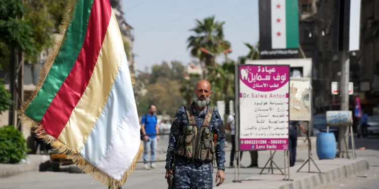 Un miembro de las fuerzas de seguridad drusas monta guardia en Jaramana, a las afueras de Damasco, el 29 de abril de 2025, tras los enfrentamientos sectarios ocurridos durante la noche. (Rami al SAYED / AFP)