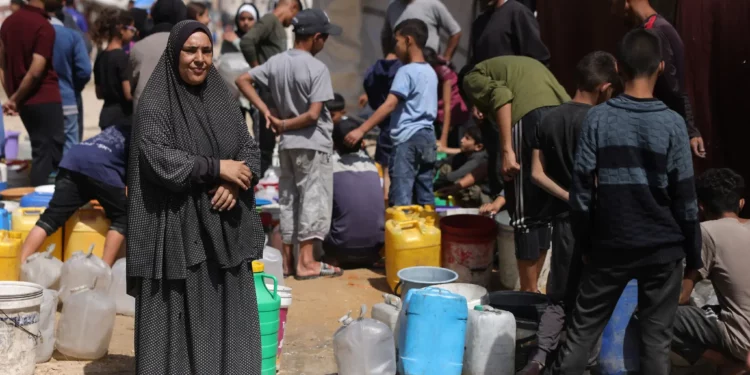 Palestinos recogen agua en un campamento para desplazados en la ciudad de Gaza, el 20 de mayo de 2025 (Bashar TALEB / AFP)