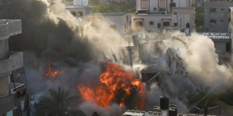 Una imagen muestra una casa siendo alcanzada por un ataque aéreo israelí en la ciudad de Gaza el 13 de mayo de 2023. (Majdi Fathi/AFP)
