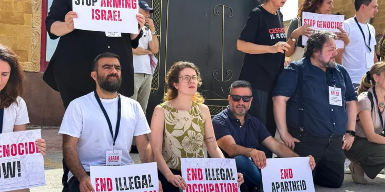 Miembros del Parlamento italiano y europeo sostienen pancartas durante una protesta frente al lado egipcio del cruce de Rafah, pidiendo el fin de la guerra en Gaza y que se permita la entrada de ayuda en el enclave palestino, el 18 de mayo de 2025. (Foto de AFP)