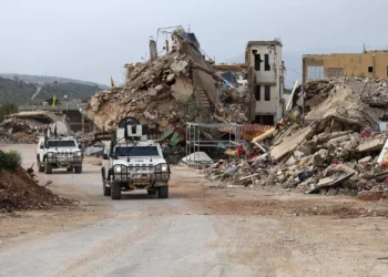 Las fuerzas de paz de las Naciones Unidas conducen vehículos de la Fuerza Provisional de las Naciones Unidas en el Líbano (FPNUL) junto a edificios destruidos mientras patrullan la aldea de Kfar Kila, en el sur del Líbano, cerca de la frontera con Israel, el 6 de abril de 2025. (Rabih DAHER / AFP)