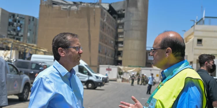 El presidente Isaac Herzog (izq.) visita el lugar del ataque con misiles balísticos iraníes contra el Centro Médico Soroka en Beersheba, junto con el director general del hospital, el Dr. Shlomi Codish. 19 de junio de 2025. (Kobi Gideon/GPO)