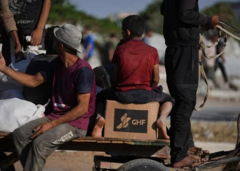Palestinos llevan paquetes de ayuda humanitaria cerca del centro de distribución de la Fundación Humanitaria de Gaza, operado por la organización respaldada por Estados Unidos, en Jan Yunis, sur de la Franja de Gaza, el 26 de junio de 2025. (Foto AP/Abdel Kareem Hana)