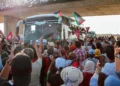 La gente aplaude cuando un convoy de autobuses compuesto por activistas, abogados y profesionales médicos del norte de África parte de Túnez a Gaza para romper el bloqueo de Israel sobre el territorio gobernado por Hamás, en Gabes, Túnez, el 9 de junio de 2025. (AP Foto)