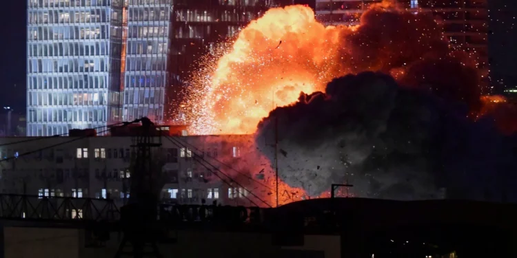 Se observa una explosión durante un ataque con misiles iraníes en Tel Aviv, a última hora del 13 de junio de 2025. (AP Foto/Tomer Neuberg)