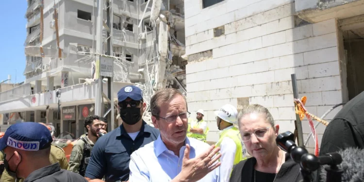 El presidente Isaac Herzog recorre el lugar de un mortal ataque con misiles iraníes en la ciudad de Bat Yam el 15 de junio de 2025 (Amos Ben Gershom/GPO)