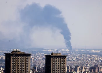 El humo se eleva a lo lejos desde una refinería de petróleo tras un ataque israelí contra la capital iraní, Teherán, el 17 de junio de 2025. (ATTA KENARE / AFP)