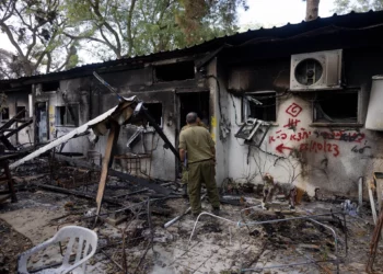 Soldados israelíes caminando junto a edificios destruidos por terroristas de Hamás en el kibutz Nir Oz el 7 de octubre de 2023, cerca de la frontera entre Israel y Gaza, en el sur de Israel, el 21 de noviembre de 2023. (Chaim Goldberg/Flash90)