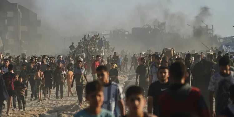 Palestinos cargan sacos y cajas con alimentos y ayuda humanitaria descargados de un convoy del Programa Mundial de Alimentos que se dirigía a la ciudad de Gaza, en el norte de la Franja de Gaza, el lunes 16 de junio de 2025. (Foto AP/Jehad Alshrafi)