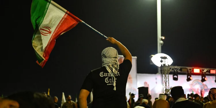 Un manifestante ondea una bandera iraní durante una protesta contra el ataque de Israel a Irán, en Basora, el 13 de junio de 2025. (Hussein FALEH / AFP)