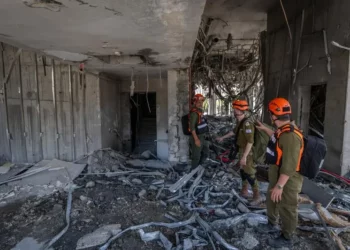 Fuerzas de seguridad y rescate israelíes en el lugar donde un misil balístico disparado desde Irán impactó y causó daños en Ramat Gan, el 19 de junio de 2025. (Chaim Goldberg/Flash90)