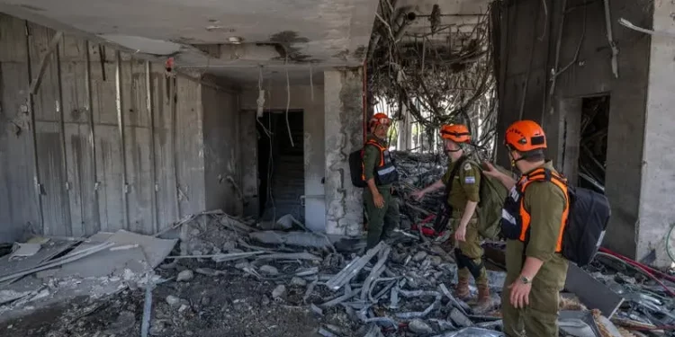 Fuerzas de seguridad y rescate israelíes en el lugar donde un misil balístico disparado desde Irán impactó y causó daños en Ramat Gan, el 19 de junio de 2025. (Chaim Goldberg/Flash90)