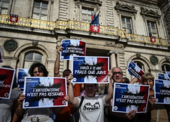 Manifestantes portan pancartas que dicen "El antisemitismo no es residual", "Más del 1000% en actos antisemitas, no son solo cifras", "Nuestras vidas valen más que el conflicto importado" y "Niña judía violada, la República en peligro", mientras se reúnen para condenar la presunta violación en grupo de una niña de 12 años por parte de un grupo antisemita, durante una manifestación en la plaza Lyon Terreaux de Lyon, en el centro-este de Francia, el 19 de junio de 2024. (Jean-Philippe Ksiazek/AFP)