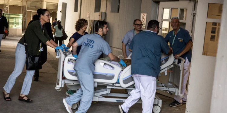 Los médicos trasladan a un paciente a un lugar seguro después de que un misil iraní impactara un edificio del Hospital Soroka en Beersheba, en el sur de Israel, el 19 de junio de 2025. (JOHN WESSELS / AFP)