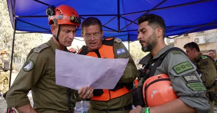 El jefe del Comando del Frente Interno, mayor general Rafi Milo (izquierda), en el lugar del impacto de un misil balístico iraní en Holón, el 19 de junio de 2025. (Fuerzas de Defensa de Israel)