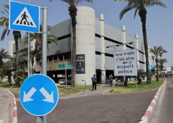 La gente pasa junto a un cartel que indica la comisaría del Aeropuerto Internacional Ben Gurion el 10 de junio de 2025. (Jack Guez/ AFP)
