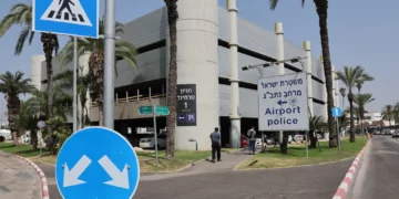 La gente pasa junto a un cartel que indica la comisaría del Aeropuerto Internacional Ben Gurion el 10 de junio de 2025. (Jack Guez/ AFP)