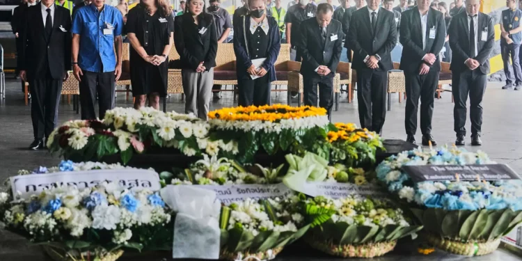Narissara Chantasang (quinta desde la izquierda), esposa de Nattapong Pinta, un trabajador tailandés que fue tomado como rehén y asesinado por terroristas en Gaza, asiste a un servicio conmemorativo silencioso cerca del ataúd que contiene su cuerpo en el Aeropuerto Internacional de Suvarnabhumi, en la provincia de Samut Prakarn, Tailandia, el 11 de junio de 2025. (Foto AP/Sakchai Lalit)