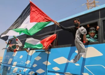 Miembros del convoy, incluyendo activistas y simpatizantes de Argelia y Túnez, ondean banderas palestinas desde un autobús mientras el grupo viaja hacia Gaza a través del cruce de Rafah en Egipto, en Zawiya, Libia, el 10 de junio de 2025. (Foto AP/Yousef Murad)