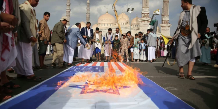 Partidarios hutíes queman banderas estadounidenses e israelíes durante una manifestación semanal antiestadounidense y antiisraelí en Saná, Yemen, el 20 de junio de 2025. (AP Foto/Osamah Abdulrahman)