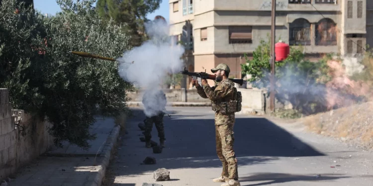 Un miembro de las fuerzas de seguridad sirias dispara un arma lanzada desde el hombro en medio de enfrentamientos en la ciudad sureña de Sweida el 16 de julio de 2025. (Omar HAJ KADOUR / AFP)