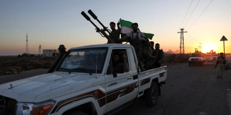 Un convoy de fuerzas gubernamentales se dirige hacia la ciudad de Sweida, donde estallaron enfrentamientos entre las tropas gubernamentales y las milicias drusas a su paso por la aldea de Mazraa, en el sur de Siria, el martes 15 de julio de 2025. (AP Foto/Omar Albam)