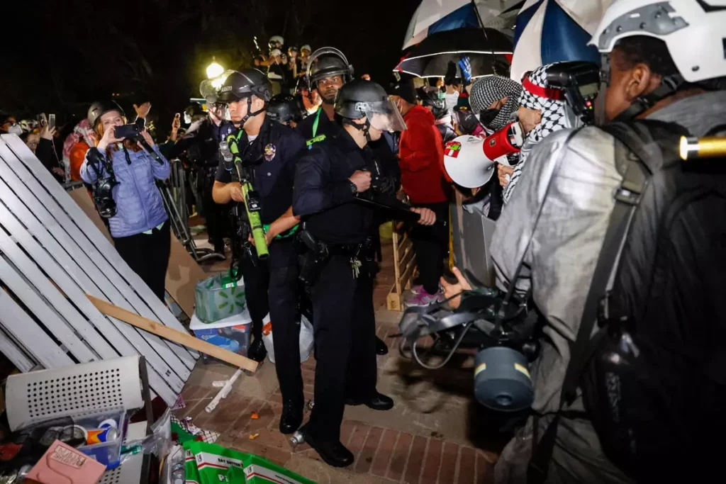 La policía irrumpe en el campamento propalestino y antiisraelí en el campus de la Universidad de California, Los Ángeles (UCLA) en Los Ángeles, California, a primera hora del 2 de mayo de 2024. (Etienne Laurent/AFP)