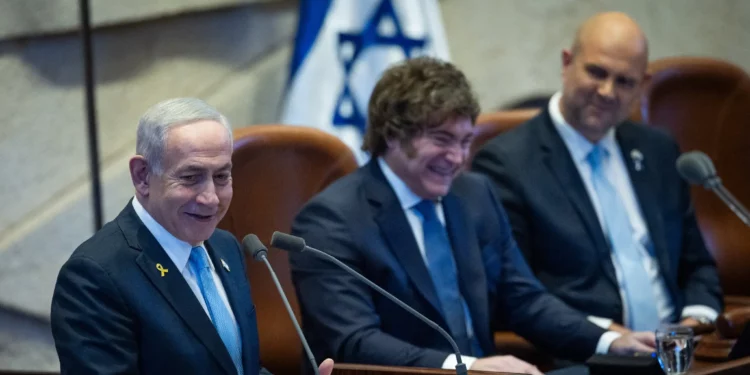 El primer ministro Benjamín Netanyahu (izquierda) habla junto al presidente argentino Javier Milei (centro) en la Knéset en Jerusalén, el 11 de junio de 2025. (Yonatan Sindel/Flash90)