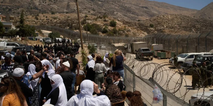 Miembros de la comunidad drusa israelí se encuentran en la frontera entre Israel y Siria, en la ciudad de Majdal Shams, el jueves 17 de julio de 2025. (AP/Leo Correa)