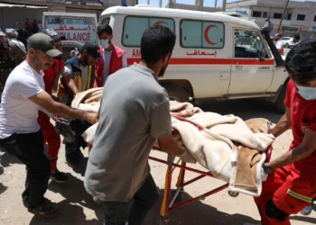 Voluntarios de la Media Luna Roja transportan a un soldado del gobierno herido en la ciudad de Sweida durante los enfrentamientos entre las fuerzas gubernamentales y las milicias drusas en una clínica en la aldea de Busra al-Harir, en el sur de Siria, el martes 15 de julio de 2025. (Foto AP/Omar Albam)