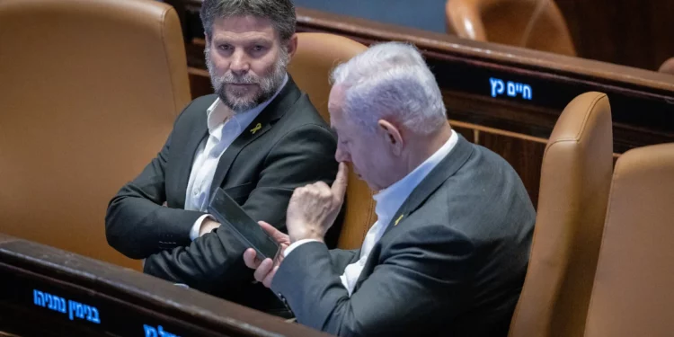 El ministro de Finanzas, Bezalel Smotrich (izquierda), y el primer ministro, Benjamín Netanyahu, asisten a una votación en el pleno de la Knéset, Jerusalén, el 31 de diciembre de 2024. (Chaim Goldberg/Flash90)