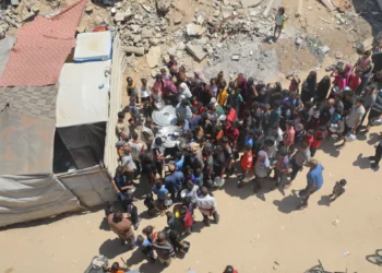 Palestinos reciben comidas de voluntarios en Deir al-Balah, en el centro de la Franja de Gaza, el 14 de julio de 2025. (Ali Hassan/Flash90)