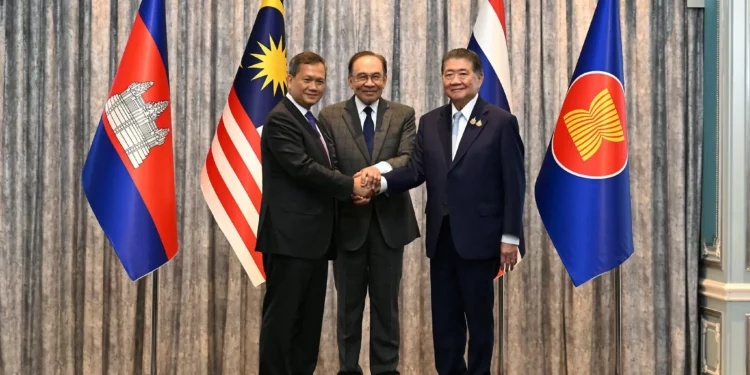 El primer ministro de Malasia, Anwar Ibrahim (centro), el primer ministro de Camboya, Hun Manet (izq.), y el primer ministro interino de Tailandia, Phumtham Wechayachai (der.), posan para fotos mientras se estrechan la mano tras una conferencia de prensa tras las conversaciones sobre un posible alto el fuego entre Tailandia y Camboya en Putrajaya, Malasia, el 28 de julio de 2025. (Mohd Rasfan / POOL / AFP)