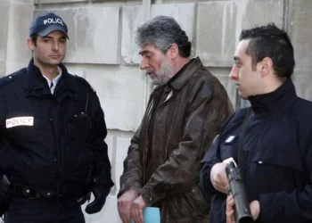 Policías franceses escoltan a Georges Ibrahim Abdallah (centro), un terrorista libanés condenado a cadena perpetua por el asesinato de dos diplomáticos, uno estadounidense y otro israelí, a su salida del juzgado de Pau, en el suroeste de Francia, el 18 de febrero de 2010. (Jean-Louis Duzert / AFP)