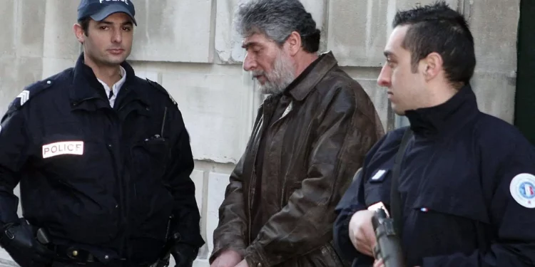 Policías franceses escoltan a Georges Ibrahim Abdallah (centro), un terrorista libanés condenado a cadena perpetua por el asesinato de dos diplomáticos, uno estadounidense y otro israelí, a su salida del juzgado de Pau, en el suroeste de Francia, el 18 de febrero de 2010. (Jean-Louis Duzert / AFP)