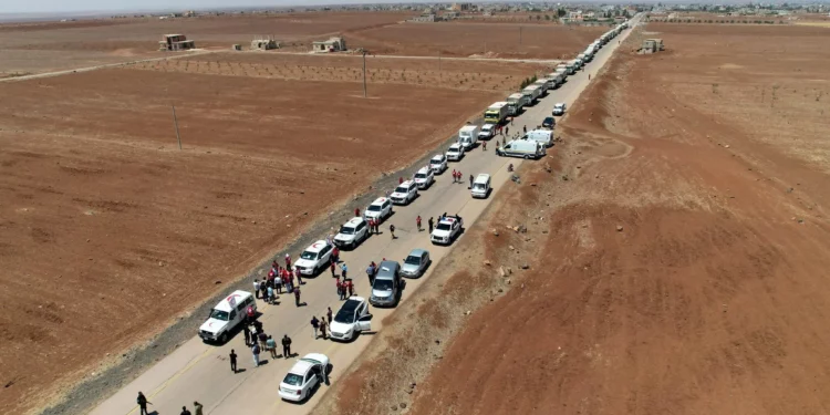 Esta fotografía, publicada por la Agencia de Noticias Árabe Siria (SANA) el 28 de julio de 2025, muestra camiones de la Media Luna Roja Siria con ayuda llegando a Busra al-Sham, en la provincia de Daraa, al sur de Siria, antes de cruzar la zona de contención hacia la provincia de Sweida. (SANA / AFP)