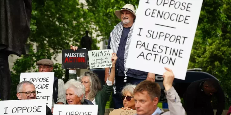 Personas participan en una protesta en apoyo a ‘Palestine Action’, organizada por el grupo Defend Our Juries, frente a la estatua de Mahatma Gandhi en la Plaza del Parlamento en Londres, Inglaterra, el 5 de julio de 2025. (Jeff Moore/PA via AP)